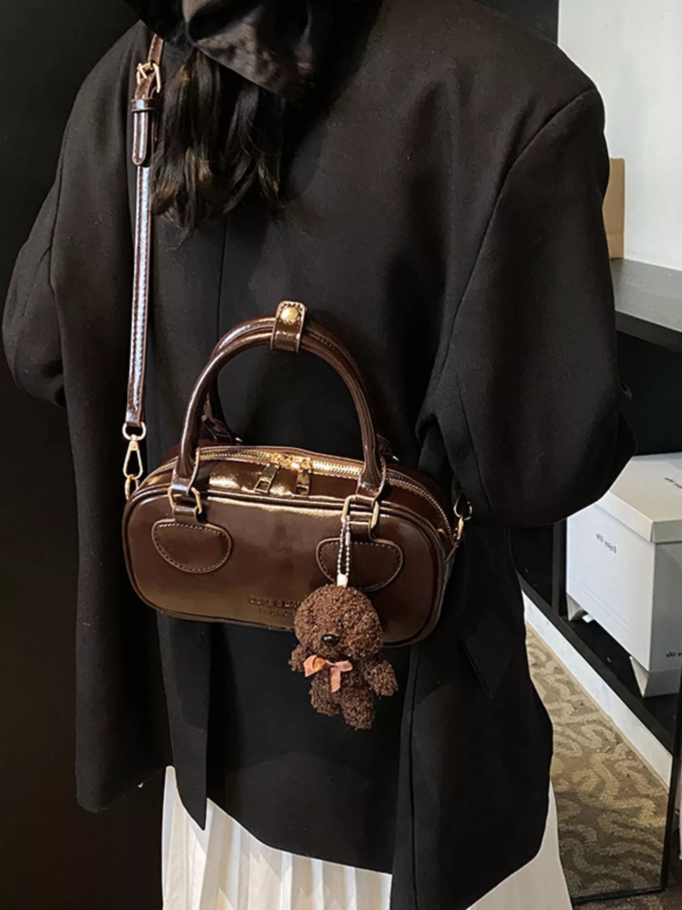 Chic mini crossbody bag in chocolate PU leather with a teddy bear charm.