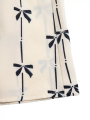 Charming Bow Print Smocked Halter Romper maternity cover up in apricot with a black bow print.