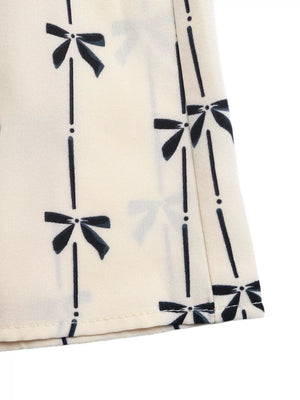 Charming Bow Print Smocked Halter Romper maternity cover up in apricot with a black bow print.