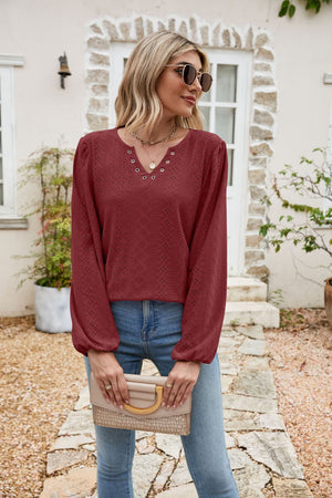 Burgundy eyelet yoke blouse with blouson sleeves and V-neckline.