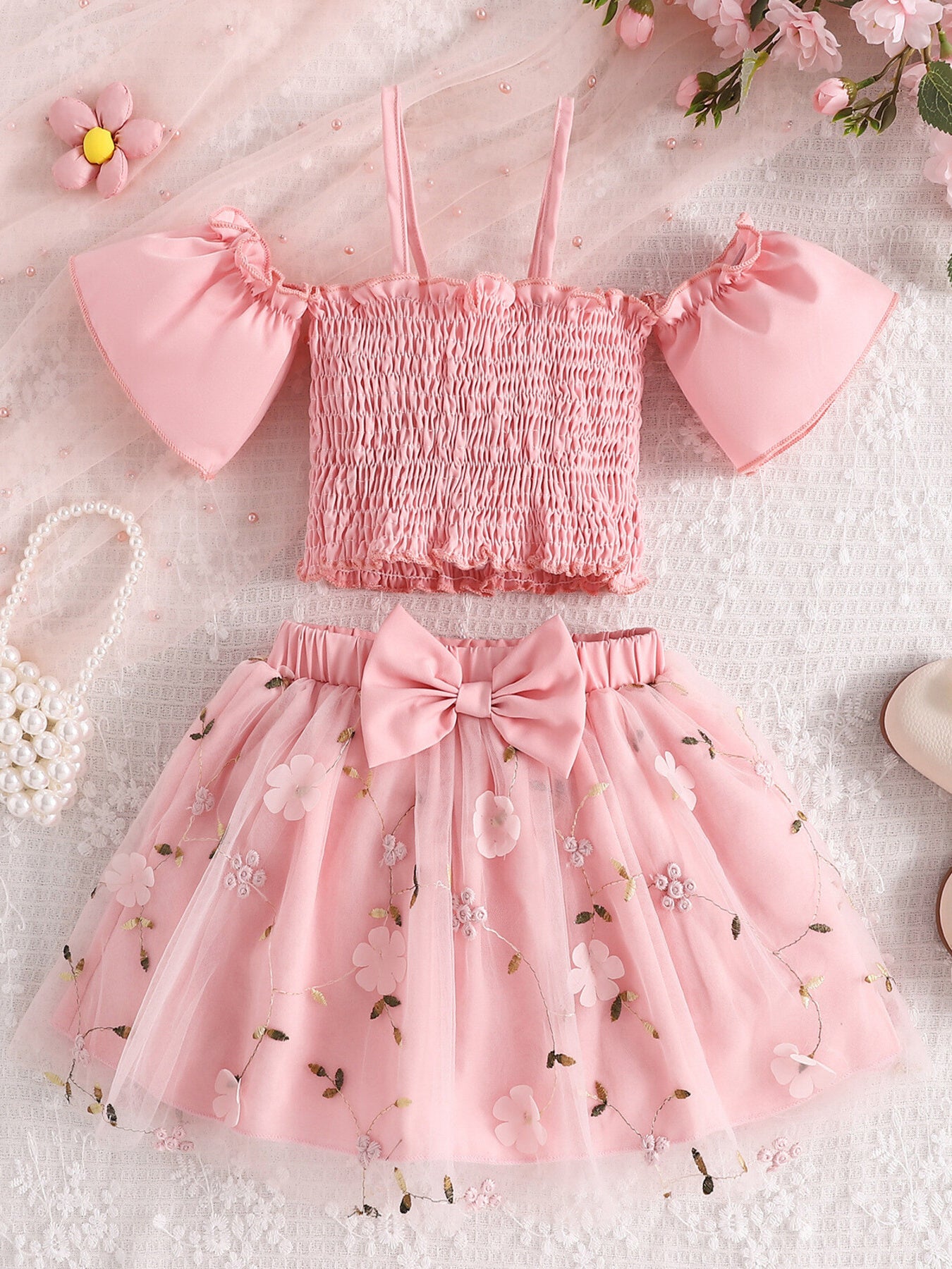 Pink smocked off-shoulder top with ruffled sleeves and floral embroidered tulle skirt with bow