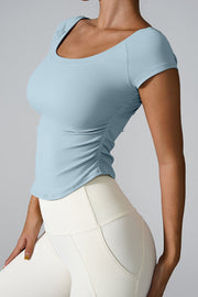 Light blue performance tee with gathered side detail and scoop neck
