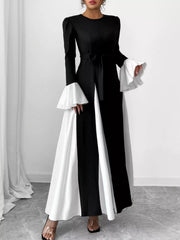 Black maxi dress with tie waist and white flare sleeves.