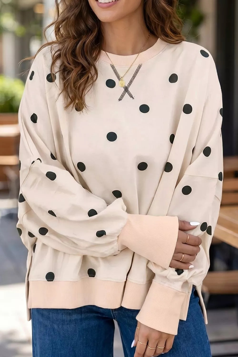 black tunic featuring ribbed cuffs and polka dot