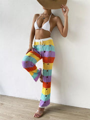 Vibrant crochet knit pants with rainbow stripes and cutouts, featuring a drawstring waist.