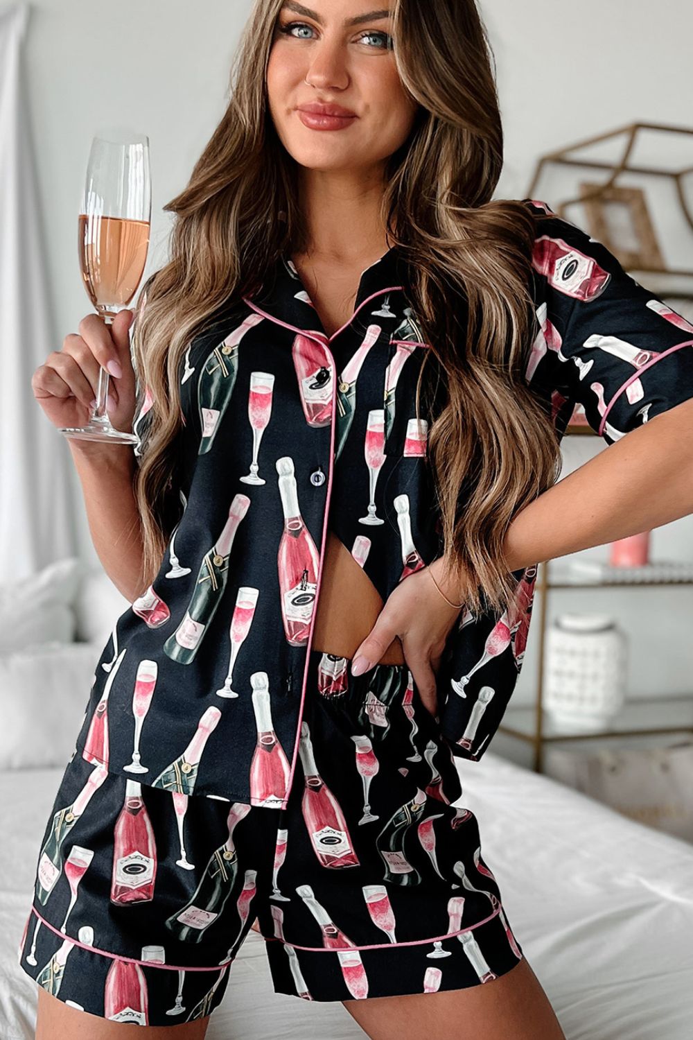Black silk pajama set with champagne print, short sleeves, and pink piping.