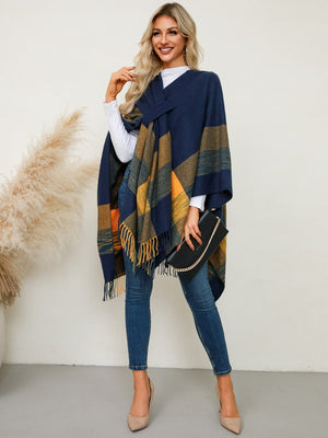 Navy plaid fringe cape with asymmetric design and tie detail, worn by a model with a clutch.