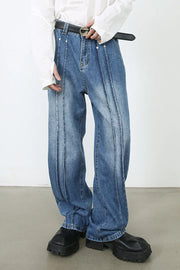 Medium wash denim trousers with vertical seams and a relaxed fit.