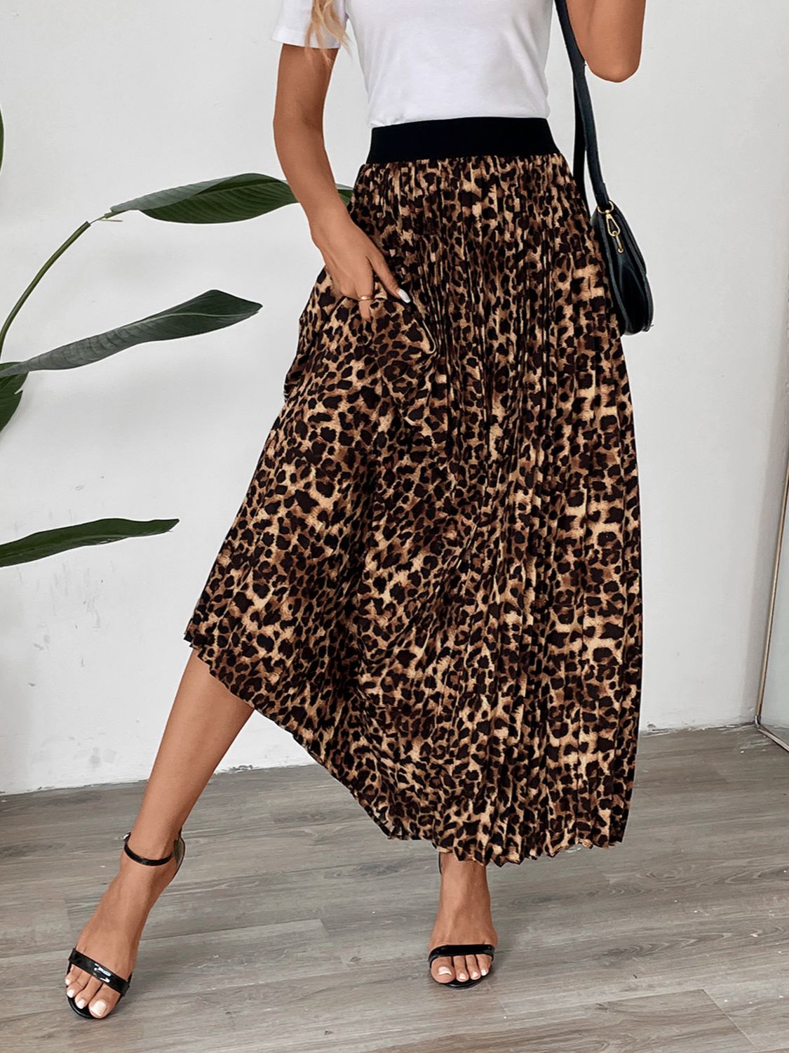 Leopard print maxi skirt with knife pleats and a black waistband.