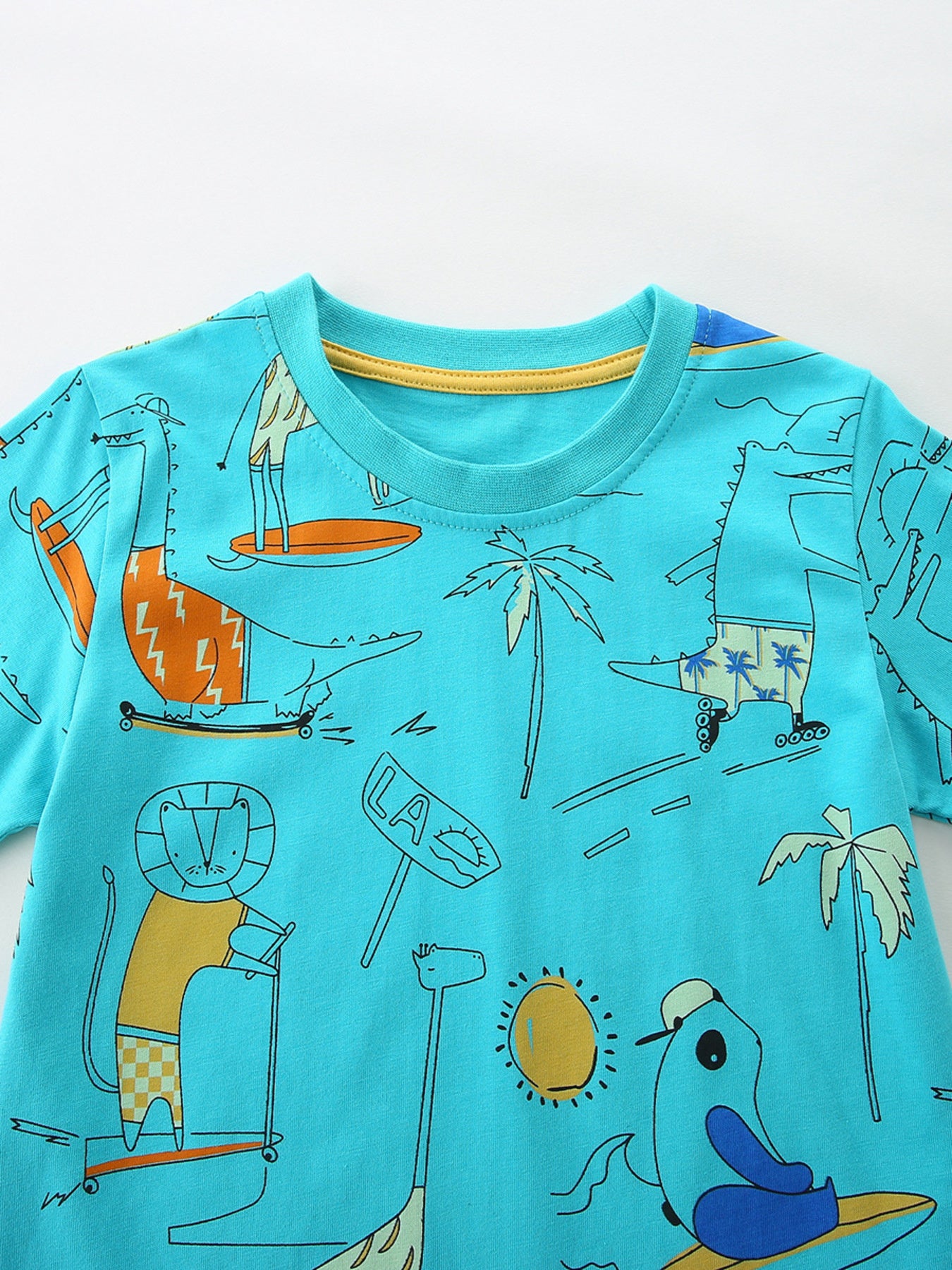Boys' cotton t-shirt in blue with a whimsical animal adventure print featuring dinosaurs, lions, and giraffes.