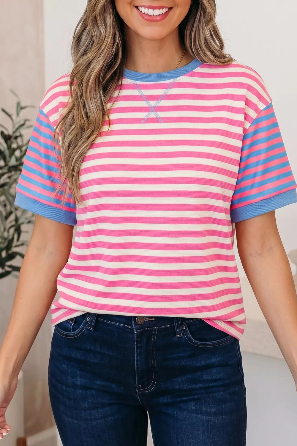 Short sleeve t-shirt with pink, white, and blue stripes and a crew neck.