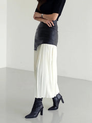 Black asymmetric leather midi skirt with white pleated chiffon overlay.