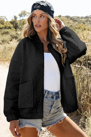 Black quilted bomber jacket with floral pattern and front pockets.