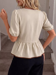 Beige V-neck blouse with short puff sleeves and ruffle hem, trimmed in brown