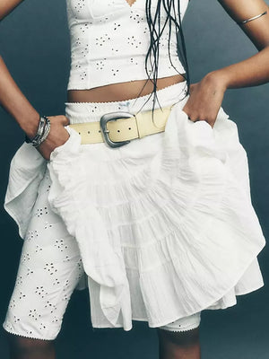 White tiered drawstring mini skirt with ruffled tiers and a yellow belt.