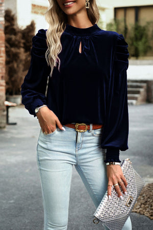 Velvet keyhole blouse with puff sleeves and smocked cuffs in dark blue.