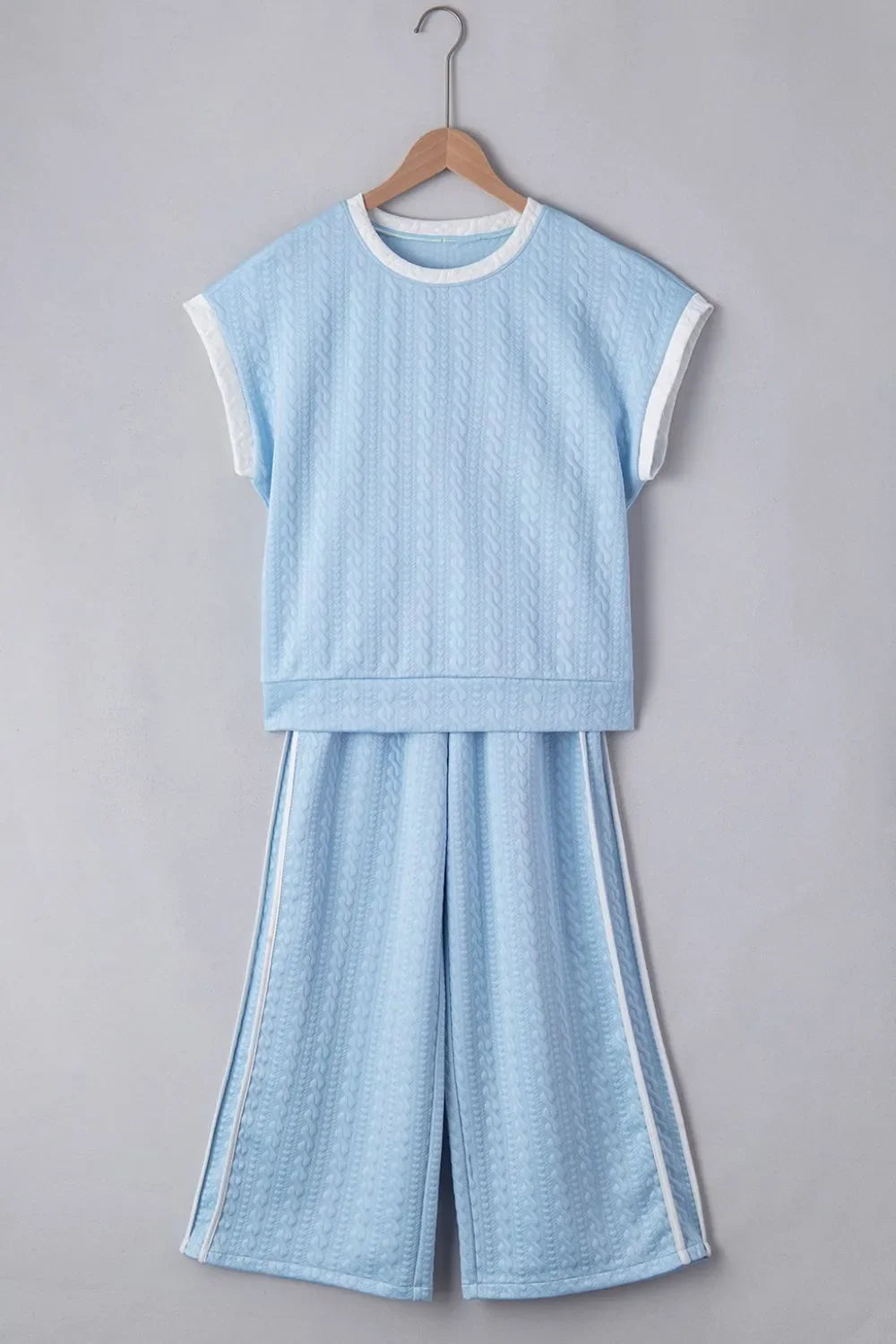 Light blue cable knit loungewear set with contrast trim on neckline, sleeves, and pants.