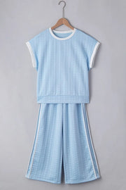Light blue cable knit loungewear set with contrast trim on neckline, sleeves, and pants.
