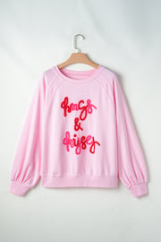 Blush pink sweatshirt with embroidered "hugs & kisses" graphic and balloon sleeves.
