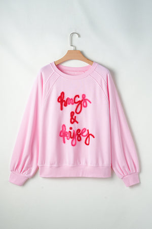 Blush pink sweatshirt with embroidered "hugs & kisses" graphic and balloon sleeves.