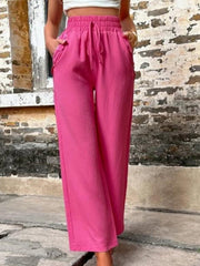 Cerise linen palazzo trousers with drawstring waist and button pocket details.
