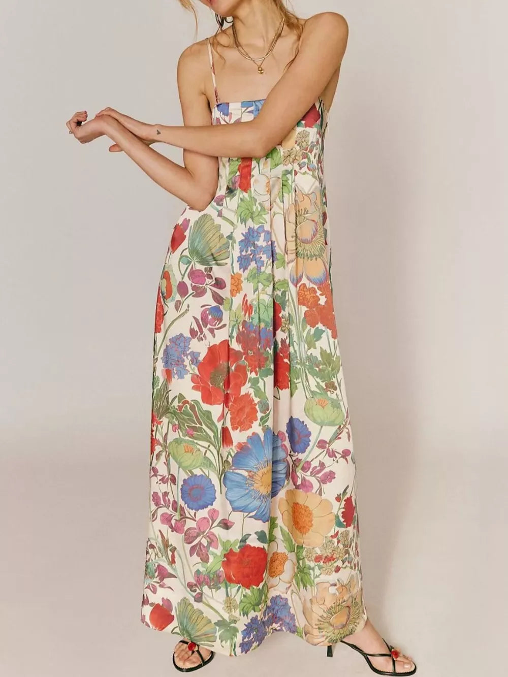 Maxi dress in ivory with vibrant floral print, gathered bodice, and spaghetti straps.