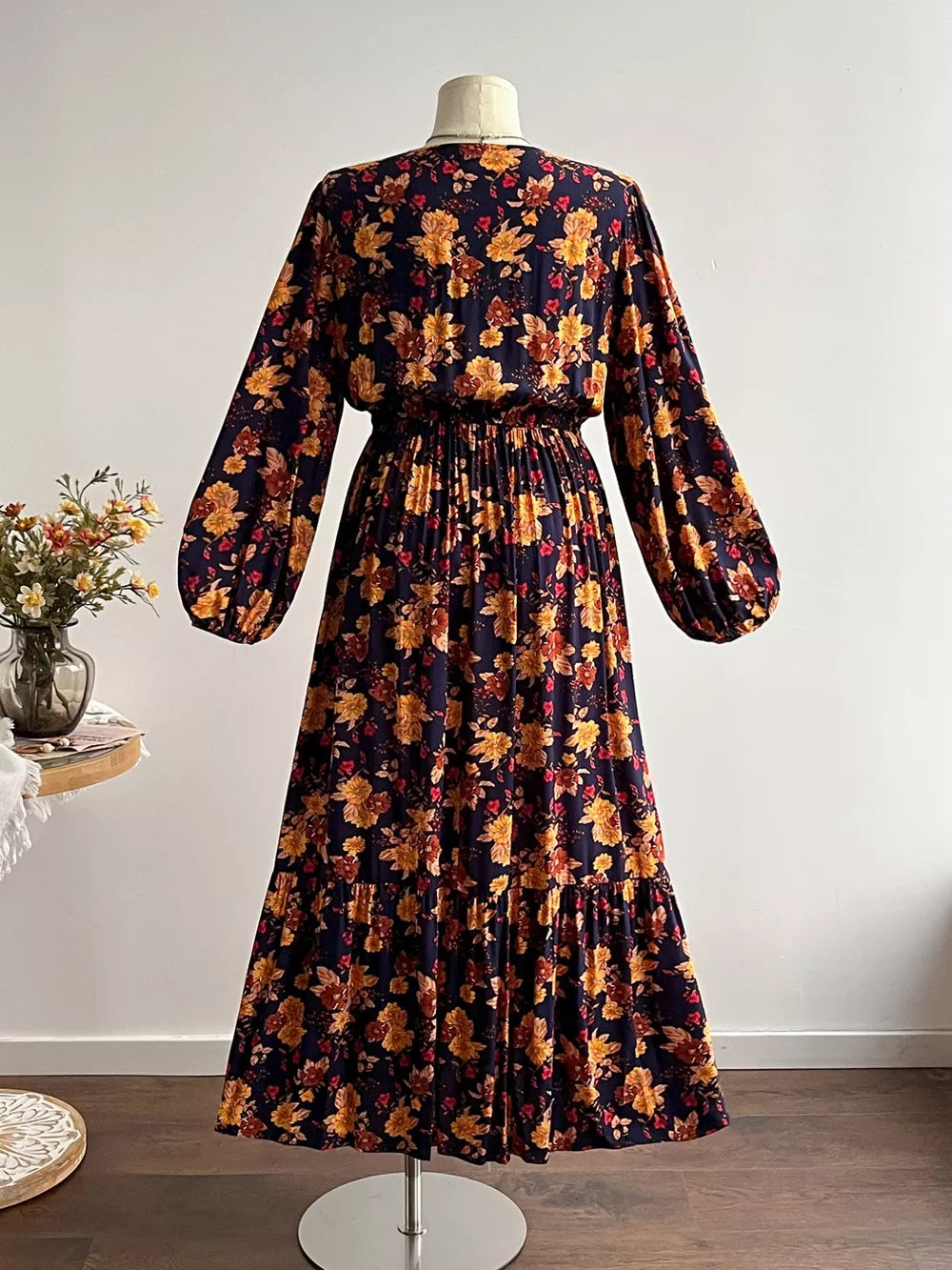 Maxi dress with V-neck, long balloon sleeves, and tiered skirt in a dark floral print.