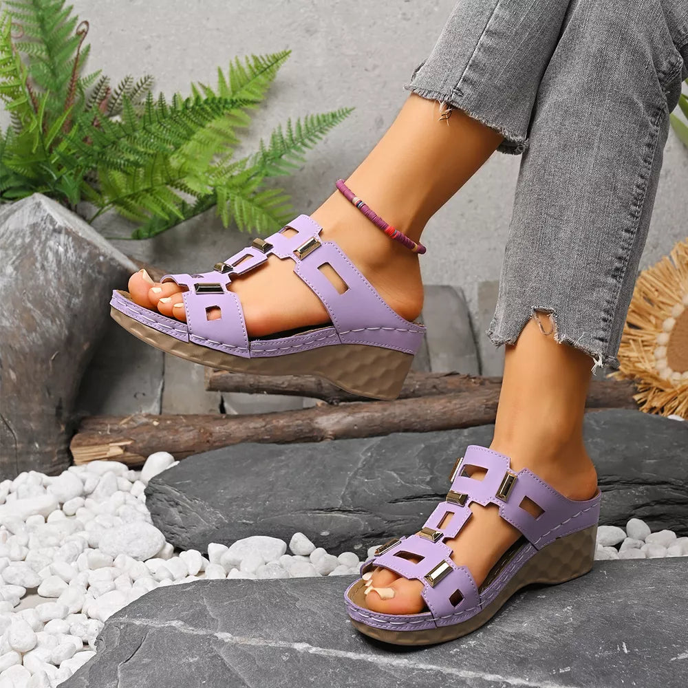 Purple open-toe wedge sandals with gold buckle details and a comfortable cushioned sole.