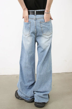 Oversized denim jeans in medium wash with distressed details and wide legs.
