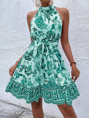 Floral print halter dress in royal blue with tie waist and ruffled hem.