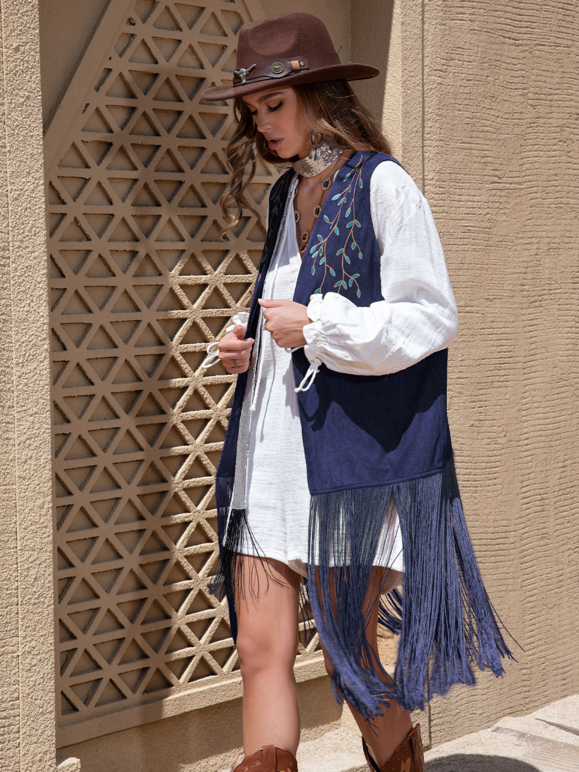 Navy faux suede vest with embroidered vines and long fringe detail.