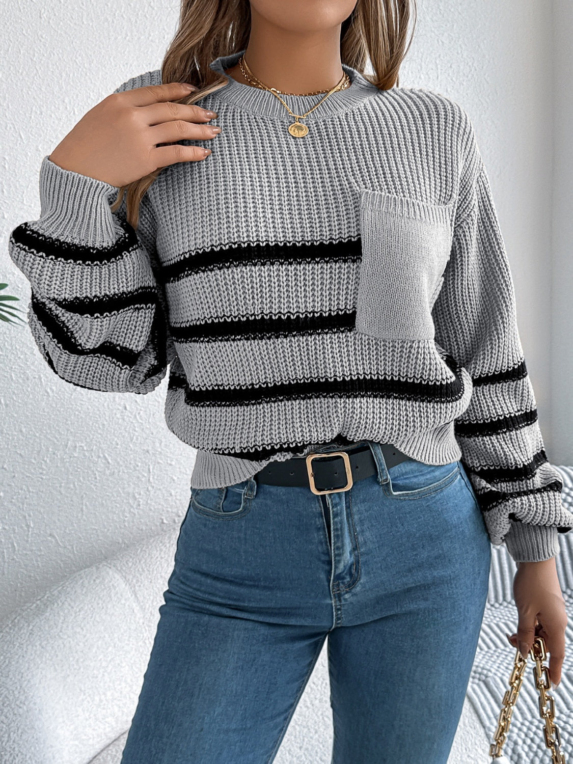 Gray striped knit sweater with a chest pocket and crew neck.