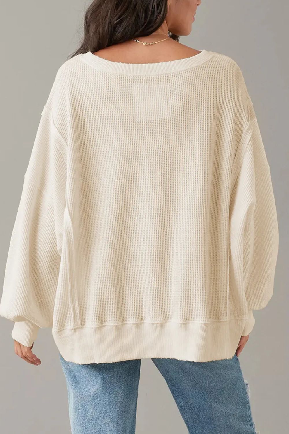 Waffle knit pullover sweater in ivory with slit sleeves and a relaxed fit.