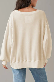 Waffle knit pullover sweater in ivory with slit sleeves and a relaxed fit.