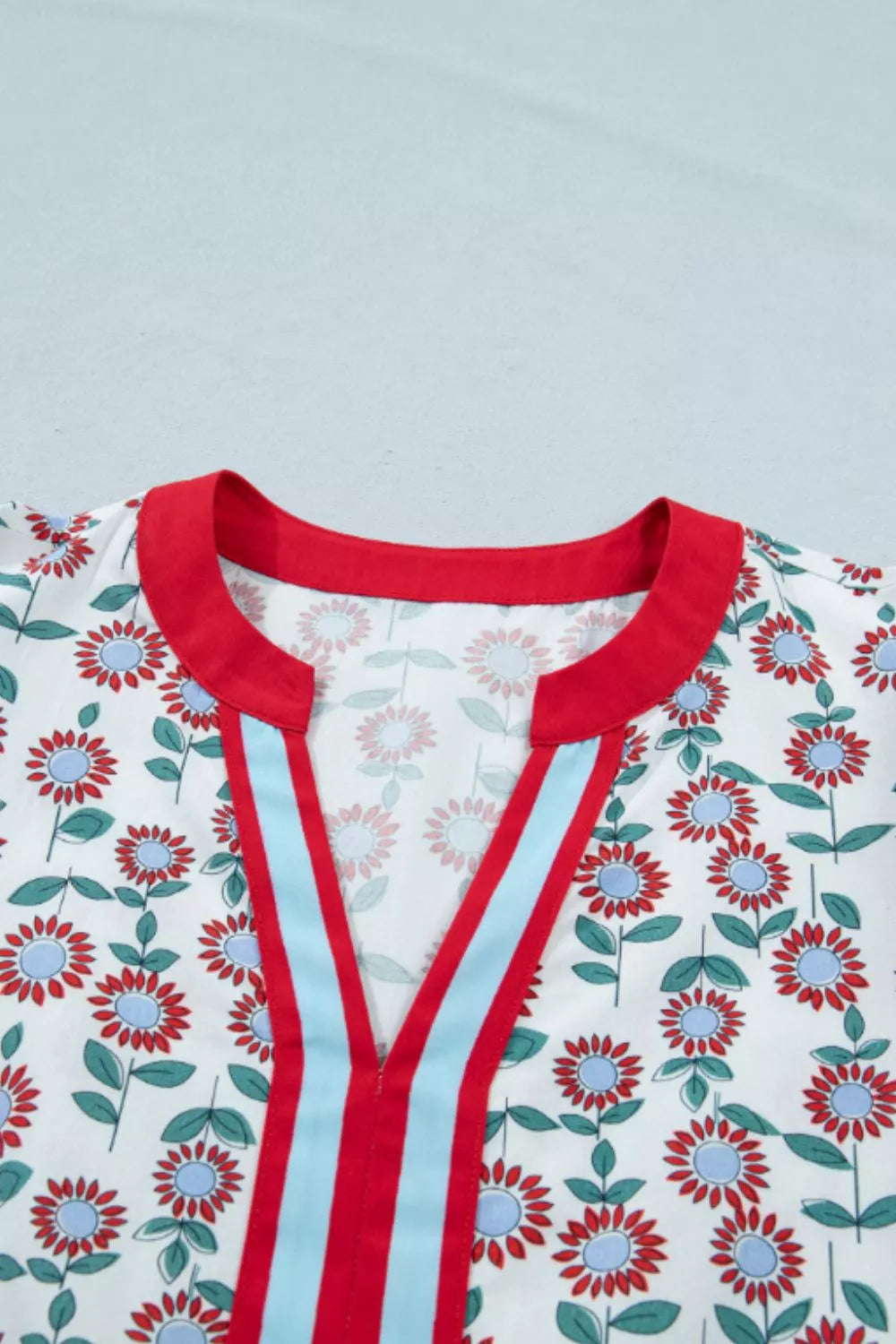 Cotton blouse with red and blue floral print, red collar, and red and blue striped V-neck detail.