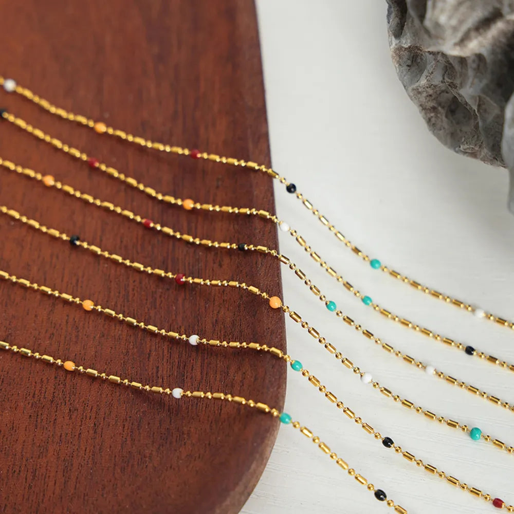Gold necklace with colorful beads and bar accents, delicate chain detail