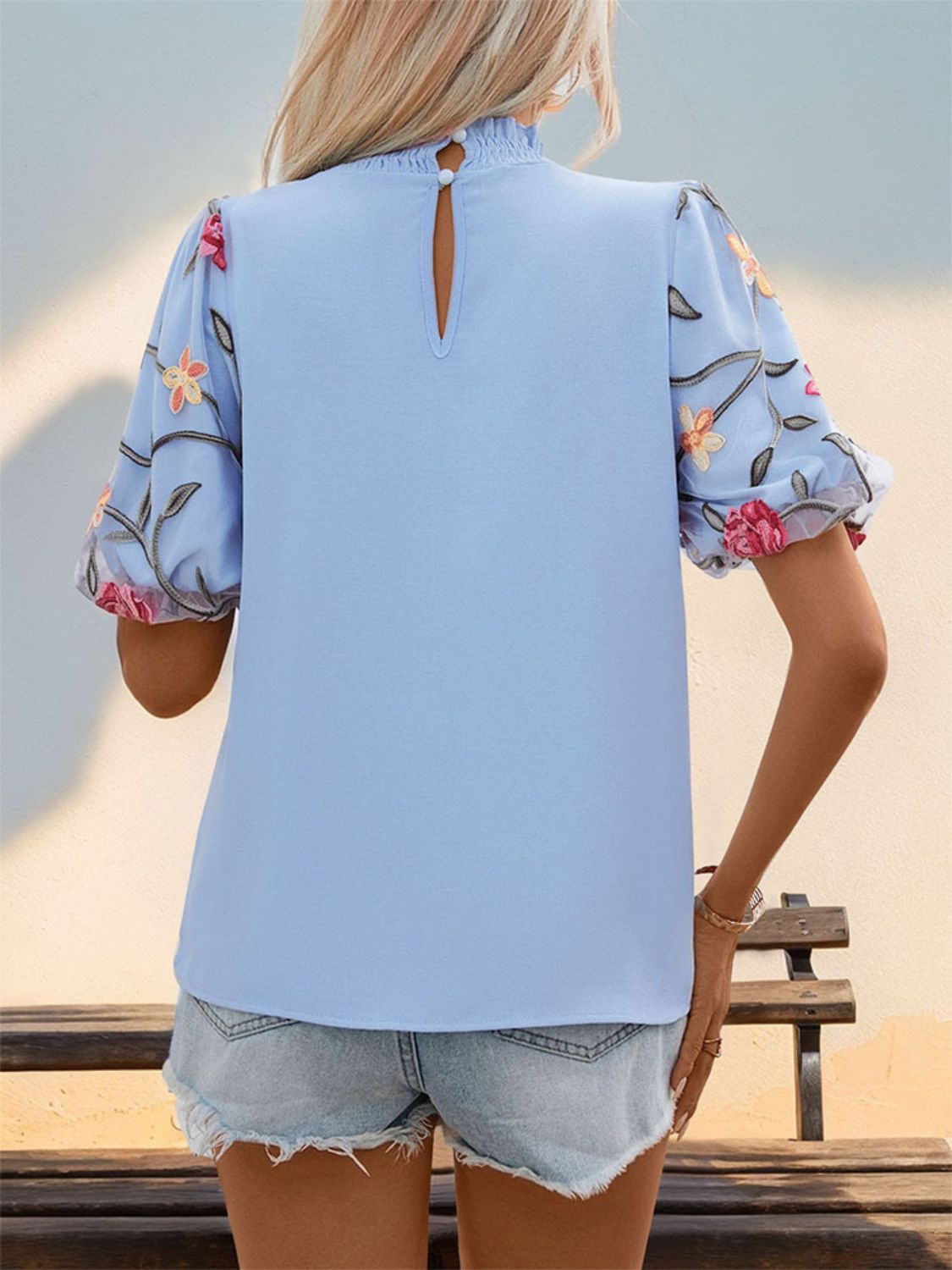Light blue blouse with floral embroidered organza puff sleeves and mock neck.