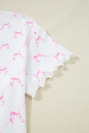 White loungewear top with pink bow print and scalloped lettuce edge sleeves.