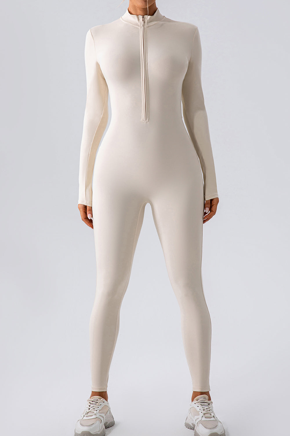 Sculpted zip-front bodycon jumpsuit in white with long sleeves and a mock neck.