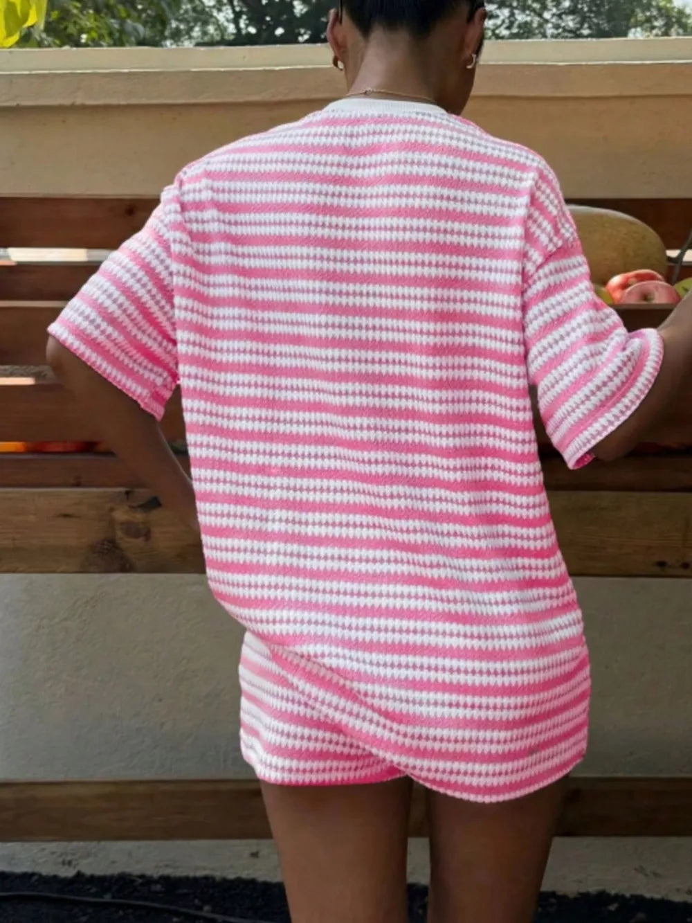 Pink striped relaxed fit two-piece set with short sleeves and shorts.