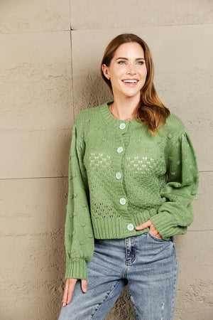 Green acrylic bubble sleeve cropped cardigan with textured detail and button front.