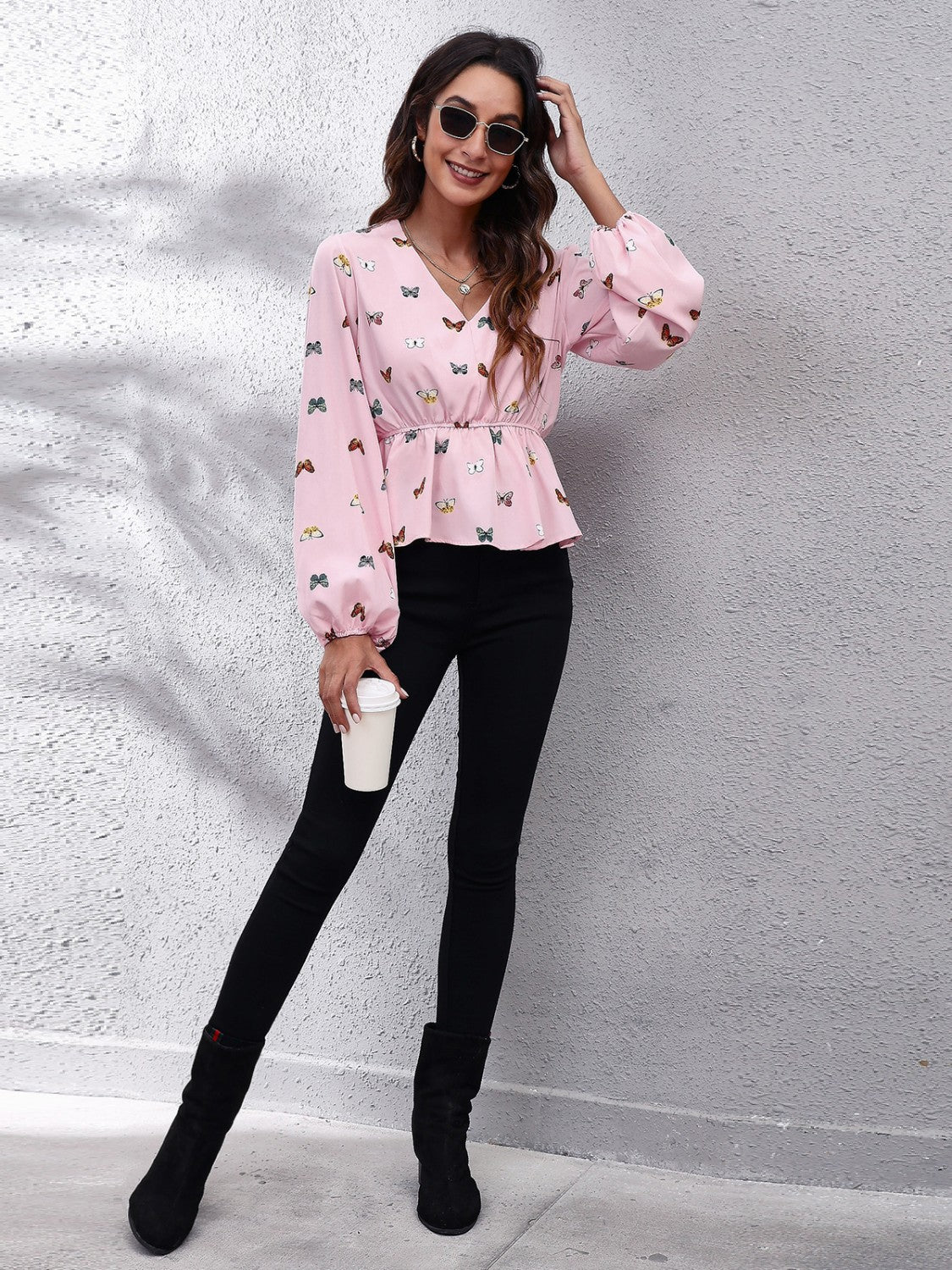 Blush pink peplum blouse with cinched waist and allover butterfly print.