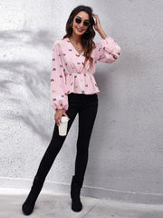 Blush pink peplum blouse with cinched waist and allover butterfly print.