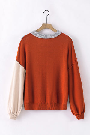 Orange and beige colorblock sweater with balloon sleeves and grey ribbed collar.