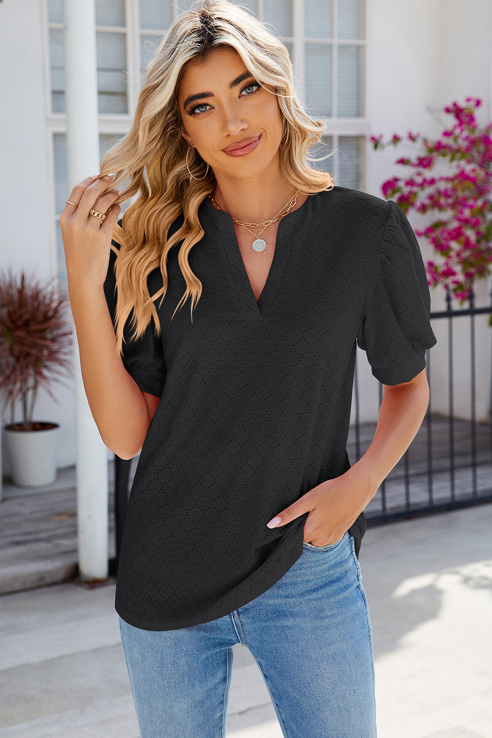 Black eyelet V-neck blouse with puff sleeves and a casual fit.