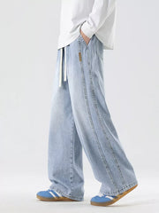 Oversized drawstring washed denim jeans in light blue with a relaxed fit and double-stitched seams.