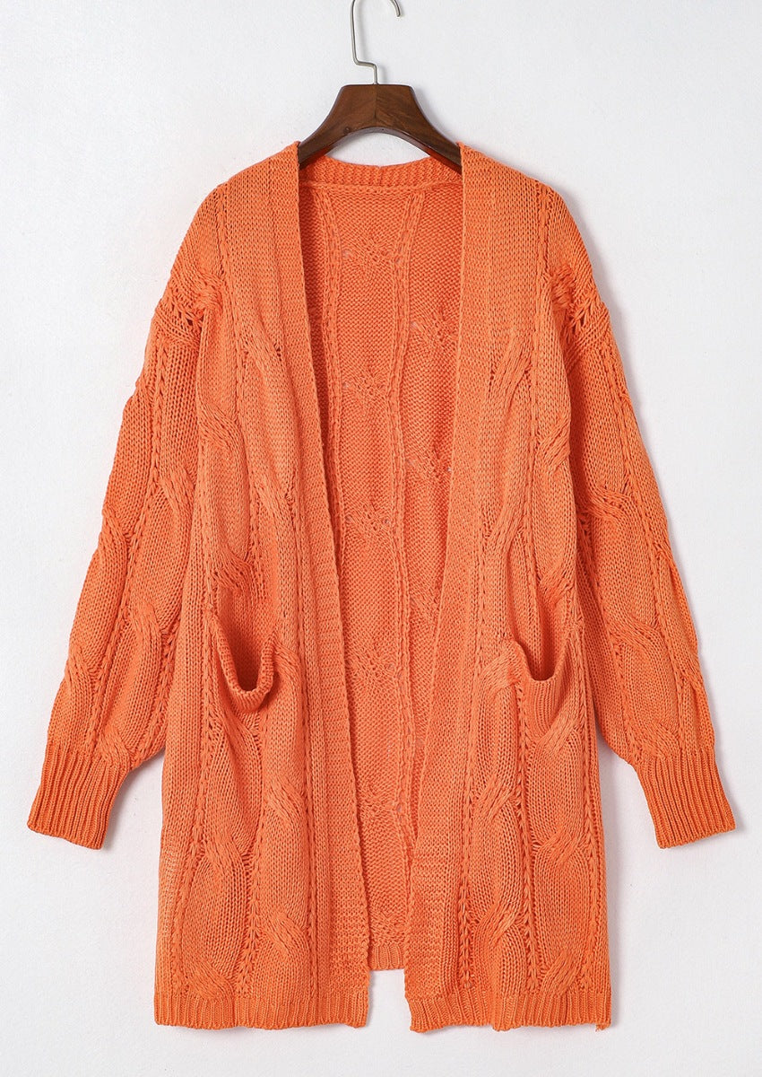 Burnt Coral cable knit open-front cardigan with pockets and textured sleeves.
