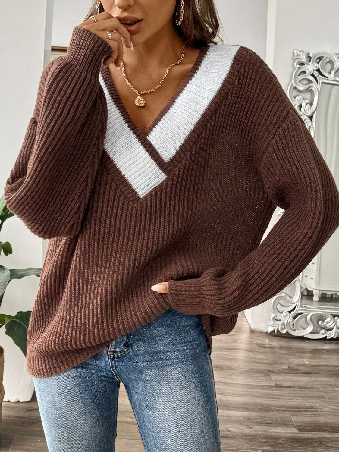 Chocolate knit sweater with white contrast trim V-neck and long sleeves.
