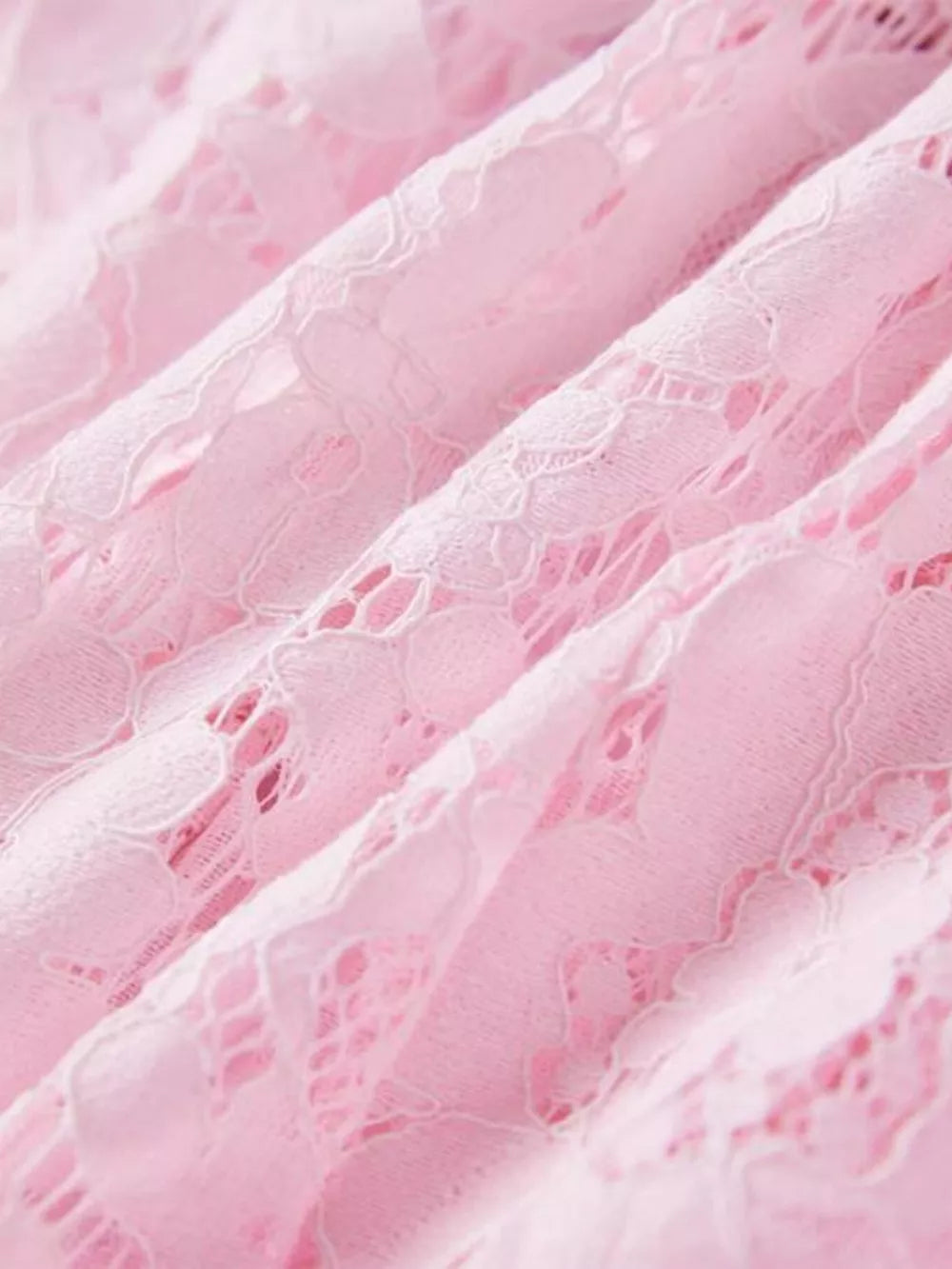 Powder pink floral lace dress detail showing intricate lace pattern and fabric texture.
