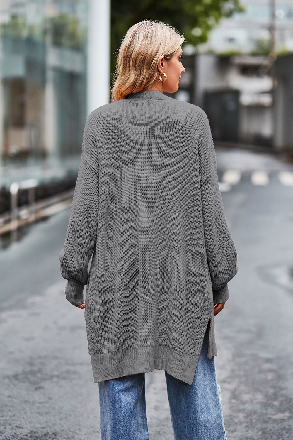 Open-knit longline cardigan in grey acrylic with side slits and balloon sleeves.